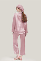 Back view of woman wearing pink Mulberry silk pajama set with matching sleep cap