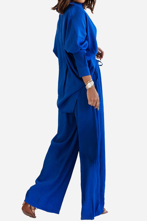 Woman wearing a stylish royal blue professional two-piece set with loose-fitting pants and a matching long top.