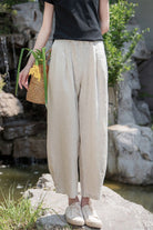 Woman wearing beige Ramie Linen Cotton Pants with relaxed fit outdoors near rocks and greenery