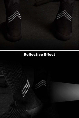 Black premium compression socks with reflective stripes showing reflective effect in low light
