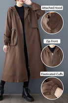 ZipLine oversized long coat in brown with attached hood, zip front, elasticated cuffs, and large zippered pockets, styled for versatile travel wear.