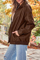 Oversized faux leather brown motorcycle jacket styled with casual jeans in autumn setting