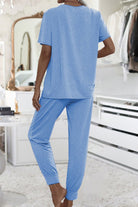 Woman wearing blue ultra-soft two-piece loungewear set with batwing sleeves and jogger pants indoors