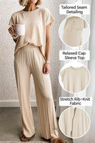 First Class Travel two-piece set with tailored seams, relaxed cap sleeve top, and stretch rib-knit fabric in neutral beige.