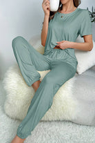 Woman wearing soft green My Go To Loungewear two-piece set relaxing with a cup of coffee.