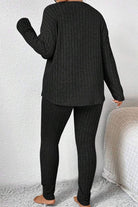 Back view of a woman wearing a black Body Confident Oversized Knit two-piece cozy knit outfit.