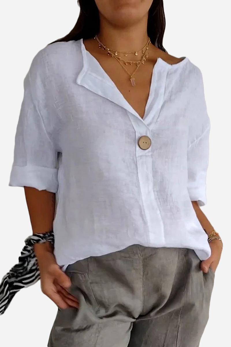 White pure linen age-defying shirt with button detail, breathable and relaxed fit, styled with casual pants and layered necklaces