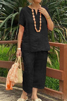Woman wearing black breezy cotton blend two-piece set with short sleeves and cropped pants outdoors