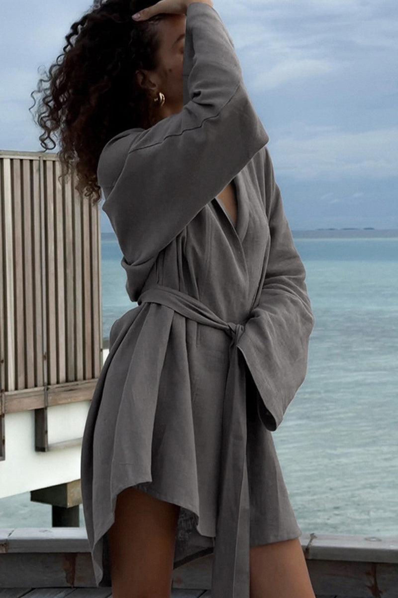 Woman wearing grey cotton-linen blend luxury spa robe tied at the waist by the ocean
