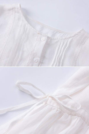 Close-up of white 100% linen coastal shift dress showing button front and waist tie detail