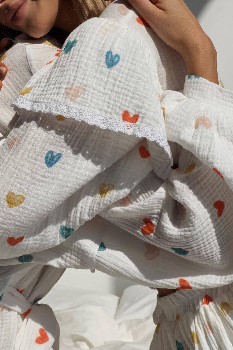 Close-up of Sweet Countryside 100 Cotton white ruffled two-piece set with colorful heart prints and lace trim sleeve detail
