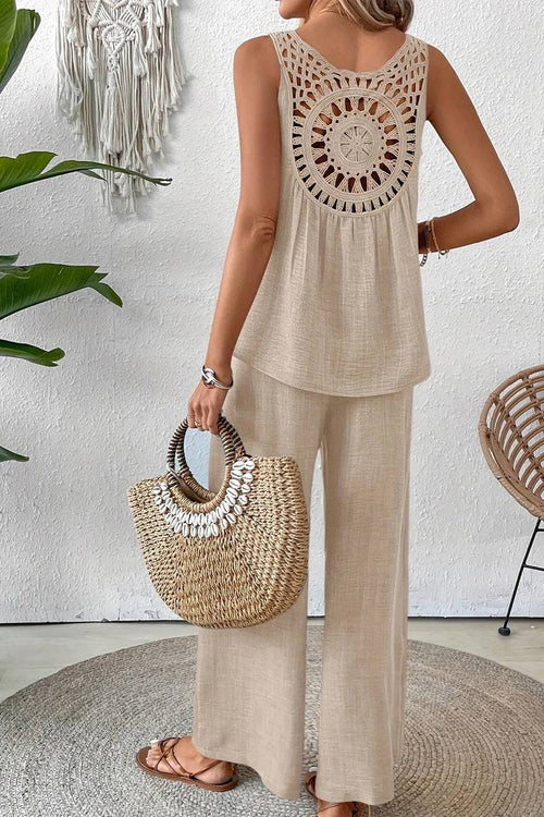 Woman wearing beige Dreamcatcher Crochet-Back sleeveless top with wide-leg palazzo pants holding woven handbag