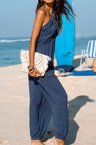 Sunshine On Sand navy halter-neck jumpsuit with ruched detail and elastic ankle cuffs on the beach