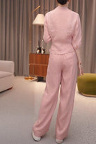 Woman wearing breathable cotton-linen pink wrap top and wide leg pants set standing indoors