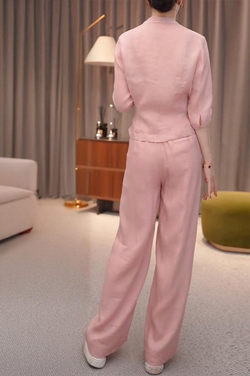 Woman wearing breathable cotton-linen pink wrap top and wide leg pants set standing indoors