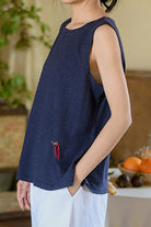Woman wearing navy blue Dandelion Fields cotton linen sleeveless top with relaxed fit and subtle embroidered detail.