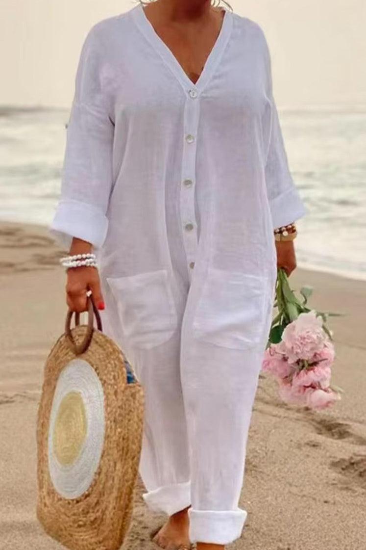 White relaxed jumpsuit with button front and pockets, perfect for warm weather beach style