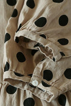 Close-up of Cottage Garden 100% linen dress fabric with black polka dots and a buttoned cuff sleeve detail