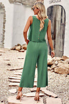 Woman wearing green sleeveless Villa Lounge Linen Set with button-back top and wide-leg pants outdoors