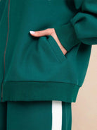 woman wearing easy airport lounge set with zip-front jacket and wide-leg pants sitting on floor