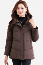 Woman wearing a brown mid-length hooded Everyday Warmth Coat with 5-layer thermal insulation and wind-resistant shell