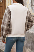 Back view of woman wearing waffle knit plaid sleeve sweatshirt with relaxed fit and blue jeans outdoors