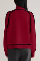 Back view of red Zero Itch Turtleneck Sweater with black contrast trim and relaxed fit on model