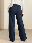 Woman wearing soft knit wide-leg pants with elastic drawstring waist and side pockets