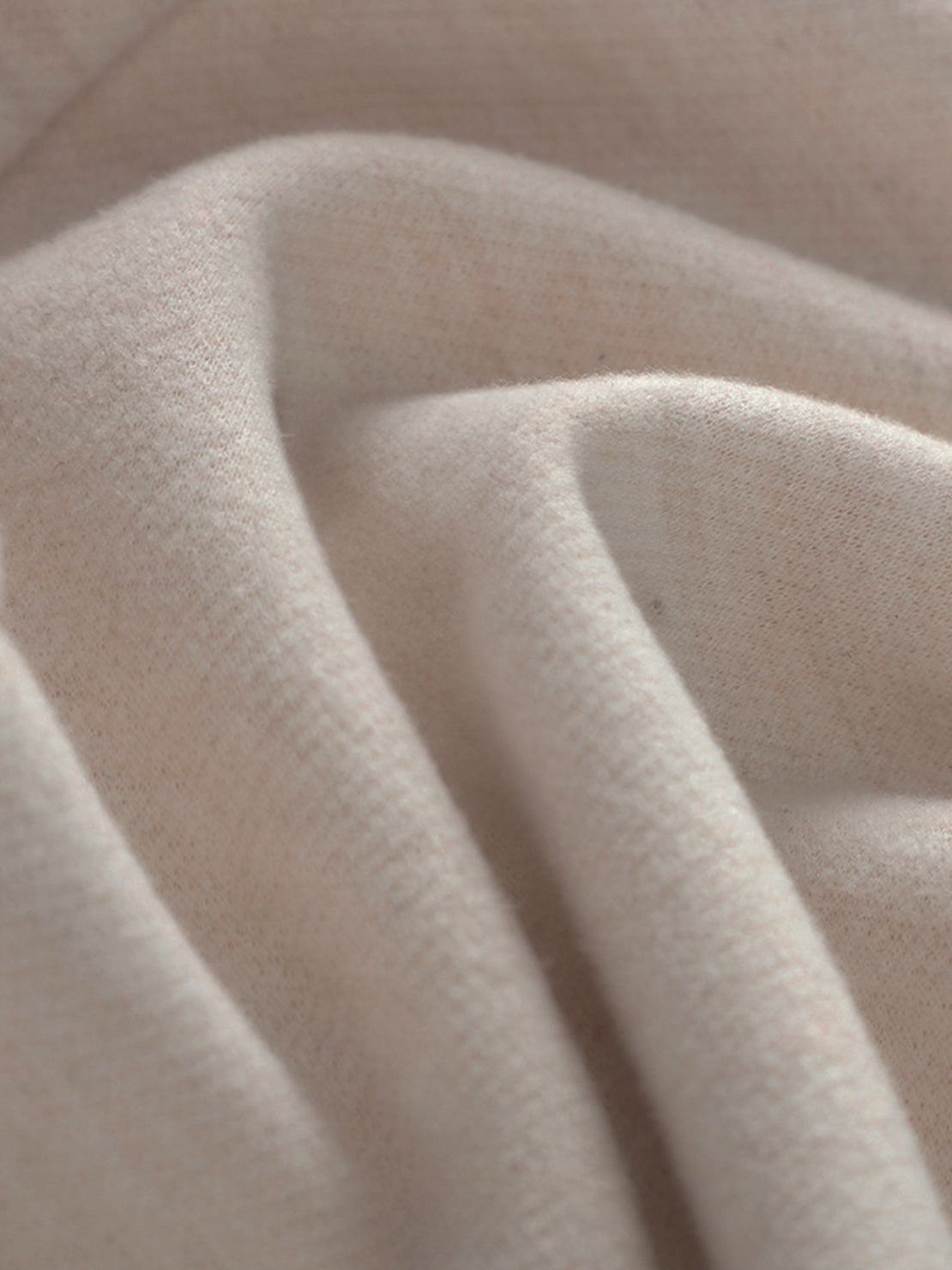 Close-up of soft beige thermal wool blend fabric for warm trousers