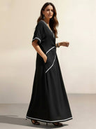 Woman wearing a knot-waist maxi dress with V-neckline and flowing skirt
