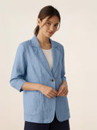 Cotton-linen blazer with notch lapels, two-button front, and relaxed fit on a white background