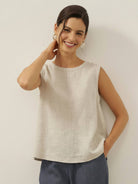 Cotton-linen sleeveless top with round neckline and button closure, relaxed A-line silhouette, hip-length for tucking or loose wear.