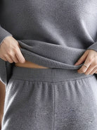Woman wearing oversized polo knit loungewear set with soft V-neck collar and straight-leg pants