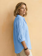 Lightweight 100% cotton popover blouse with relaxed fit, classic collar, and tunic length, featuring natural crinkle texture and roll-up sleeves.