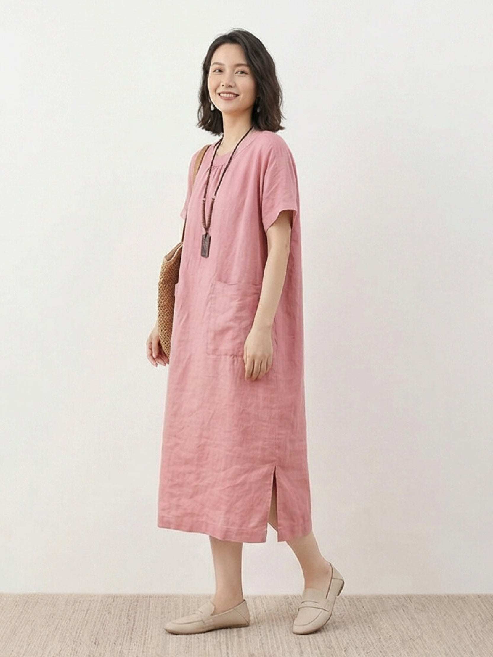 Woman wearing 100% linen pocket midi dress with short sleeves and side slits standing outdoors