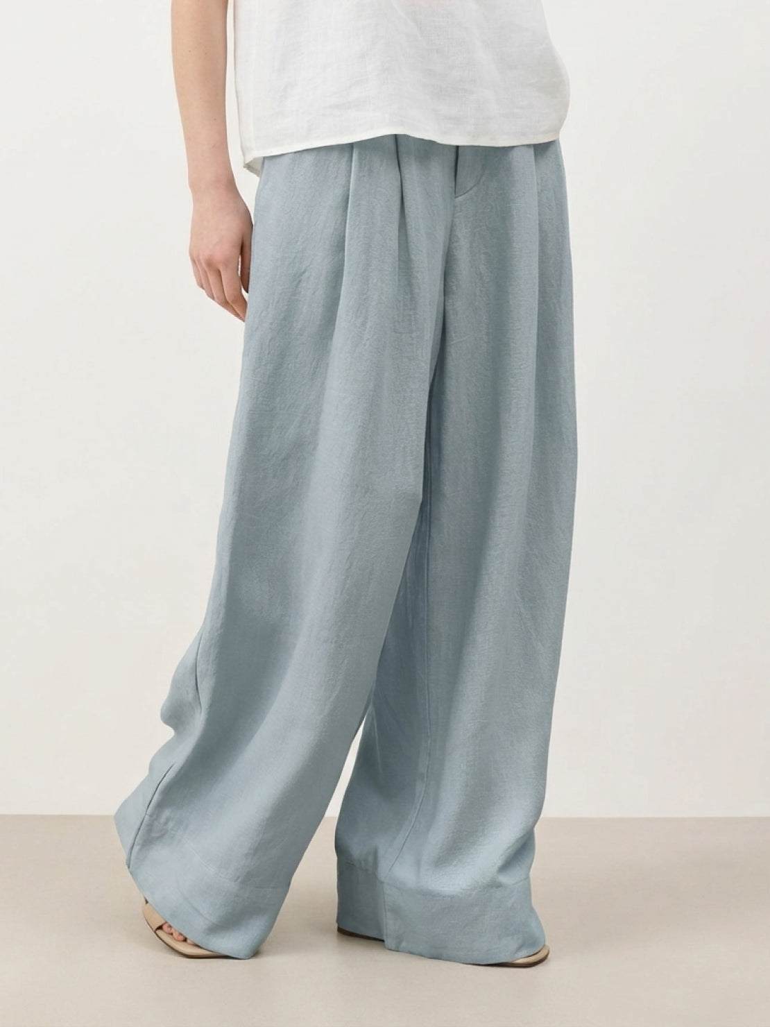 White pleated Tencel-linen wide-leg pants with hook-and-zip closure and floor-skimming silhouette