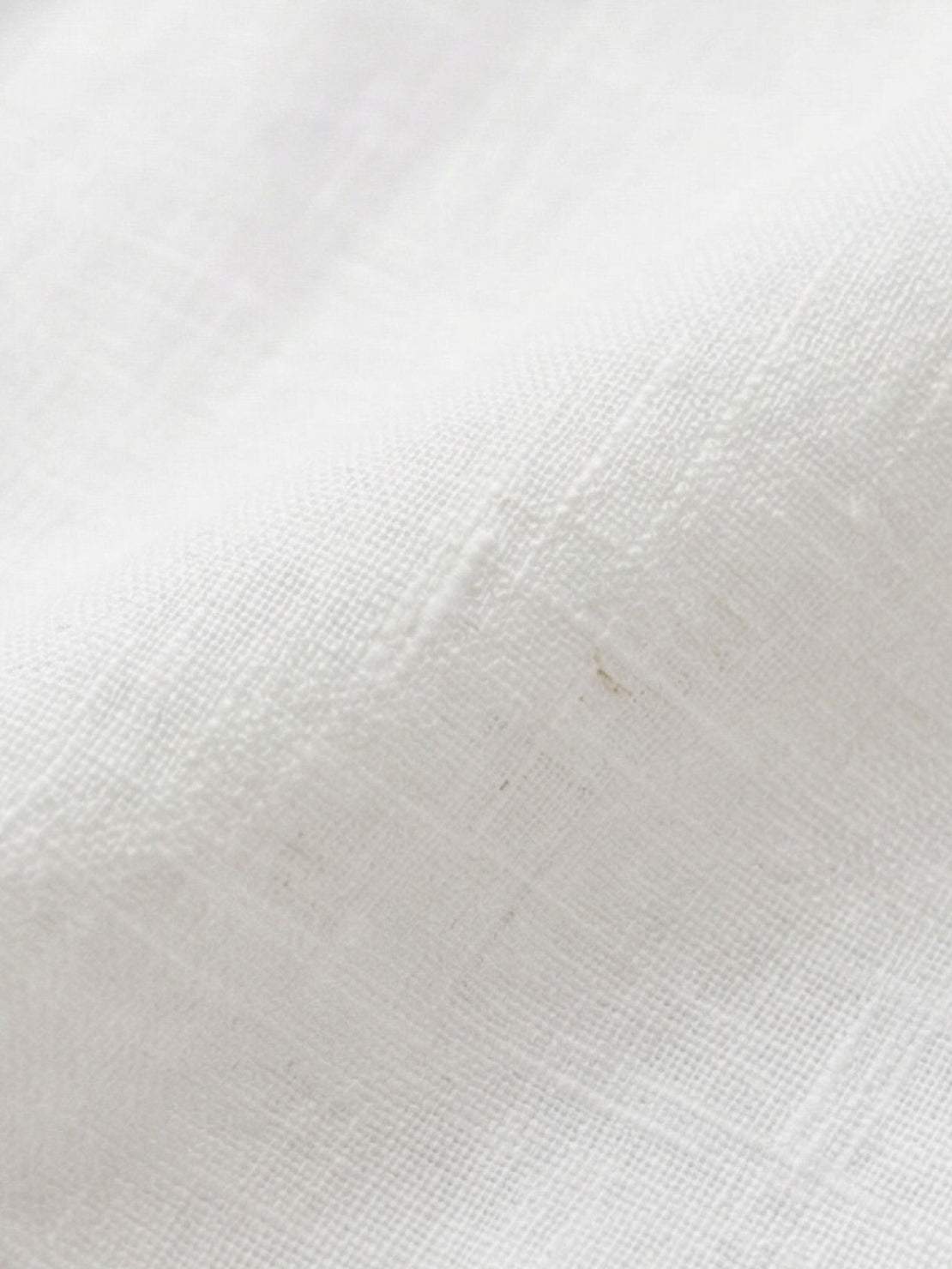 White Tencel-linen blend pleated wide-leg pants with structured waist and floor-length silhouette