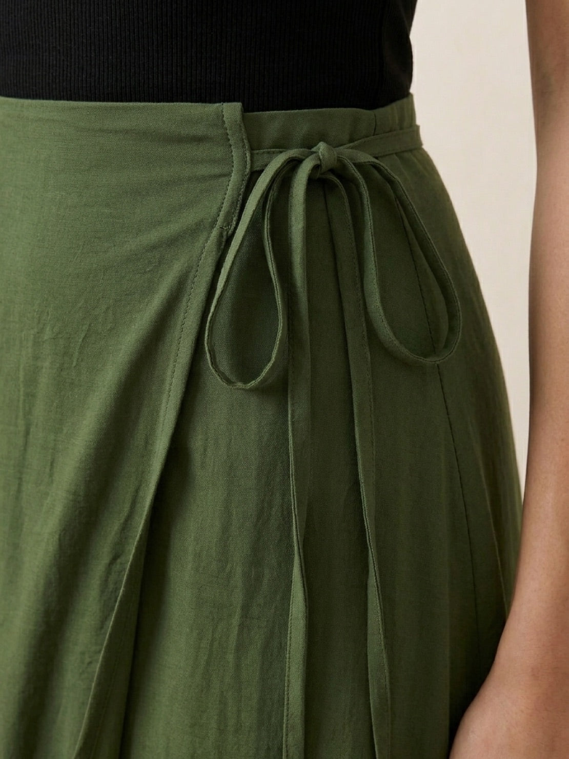 Woman wearing asymmetrical wrap maxi skirt with side tie closure and flowing fabric