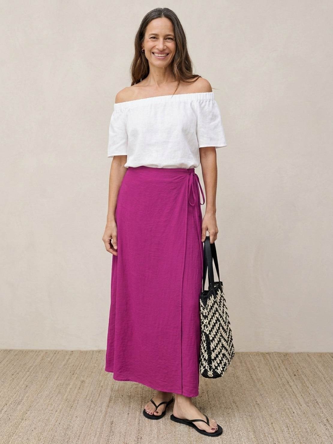 woman wearing asymmetrical wrap maxi skirt with side tie closure and flowing hem