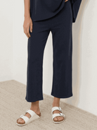 Woman wearing chocolate brown cotton-blend capelet top with batwing sleeves and wide-leg pants lounge set