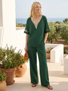 Mature woman wearing lightweight linen top with relaxed boxy shape and three-button V-neck design
