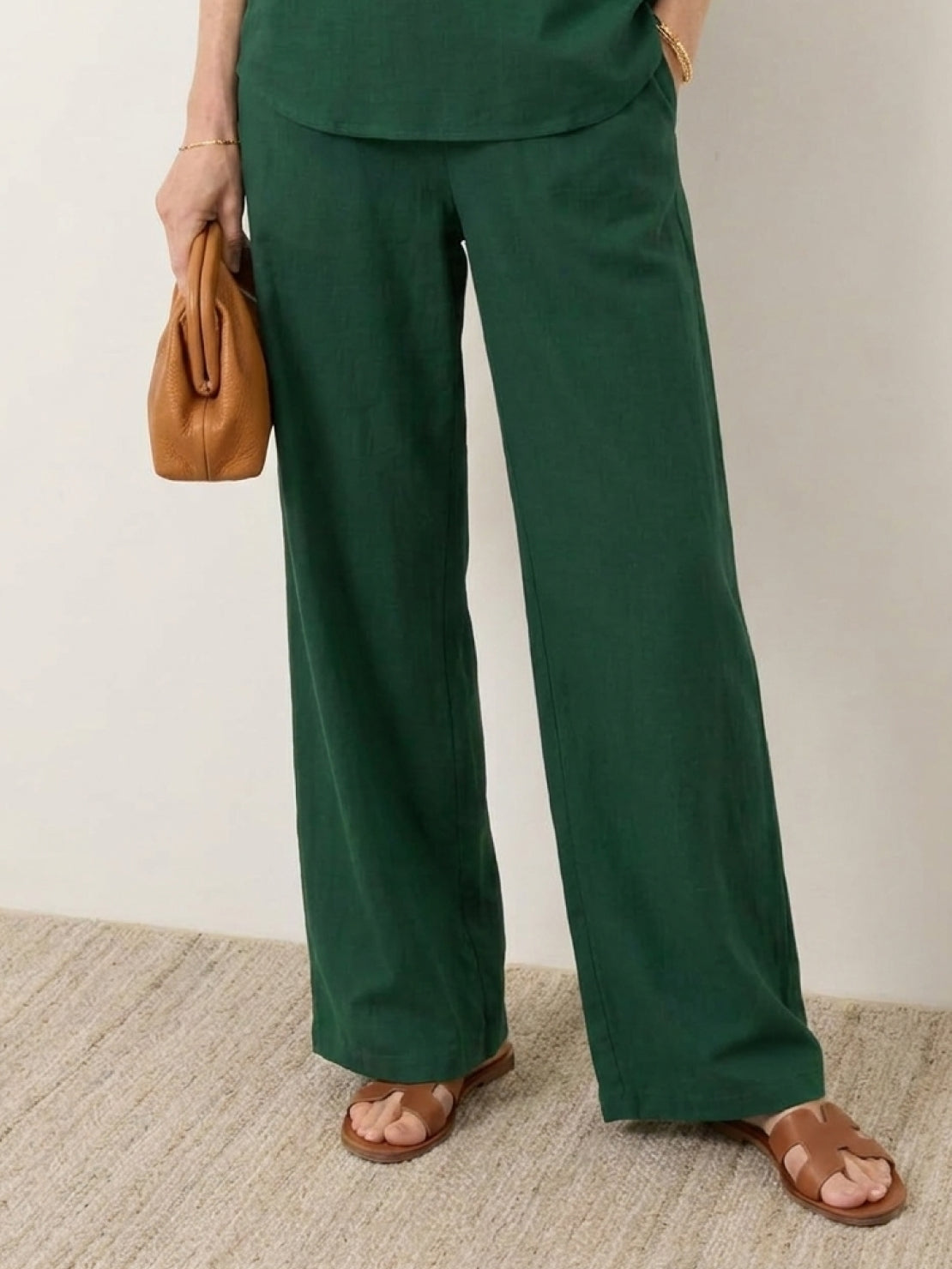 Mature woman wearing a lightweight linen top with V-neck, short sleeves, and button detail in a relaxed boxy shape