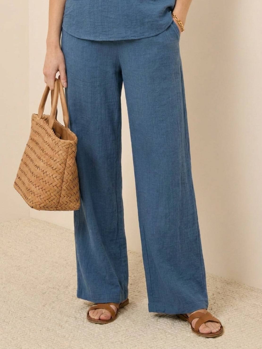 Mature woman wearing lightweight 100% linen short-sleeve V-neck top with button detail and relaxed boxy fit