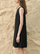 woman wearing sleeveless relaxed linen lyocell blend dress with hand-stitched neckline detail