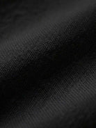 Close-up of black cotton fabric texture for short-sleeved pullover and wide trouser matching set