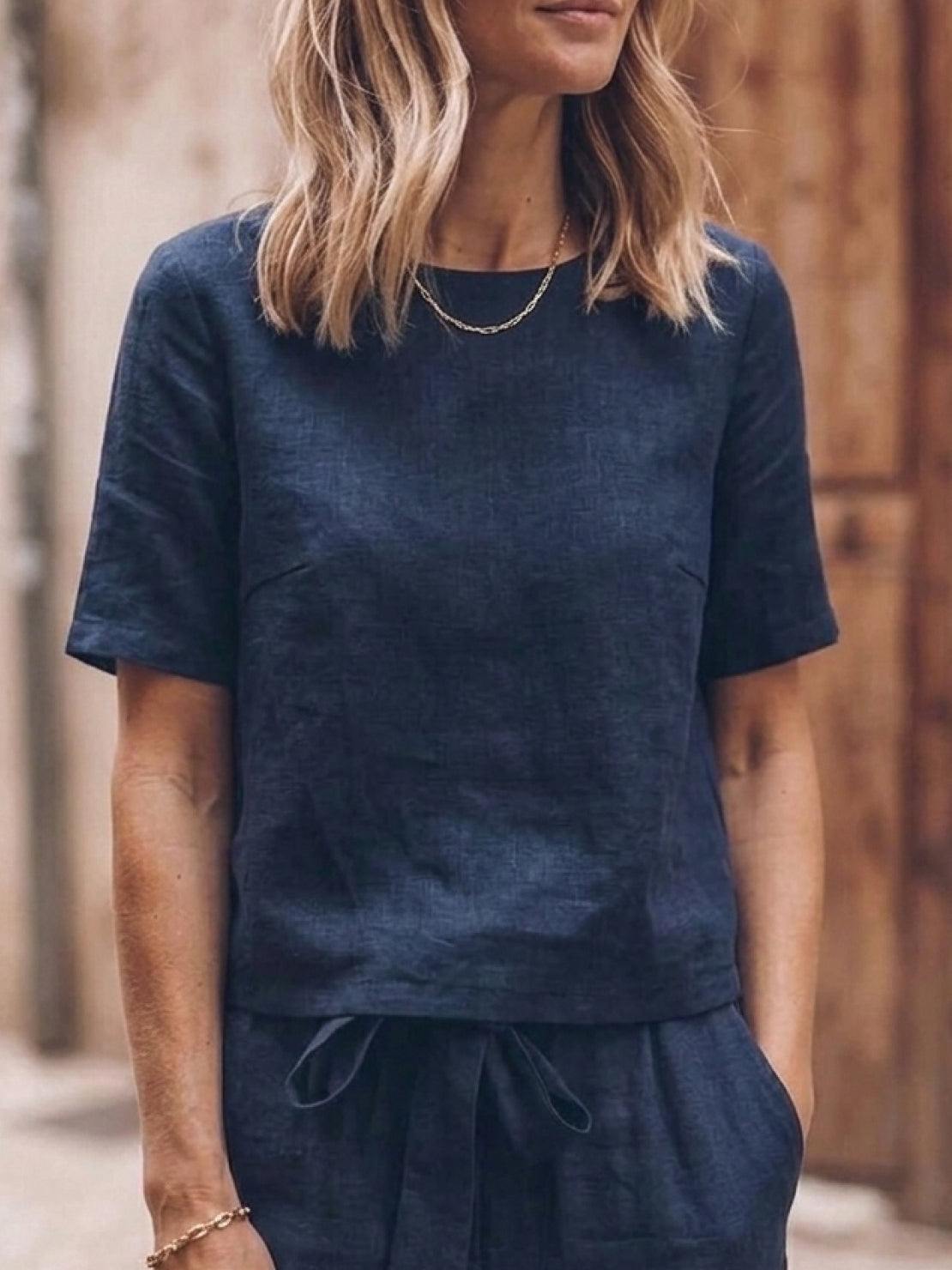 Woman wearing relaxed fit cotton linen set with short-sleeve top and straight-leg pants in monochrome tones
