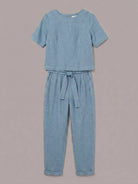 Woman wearing relaxed cotton linen set with short-sleeve top and straight-leg pants in monochrome tones