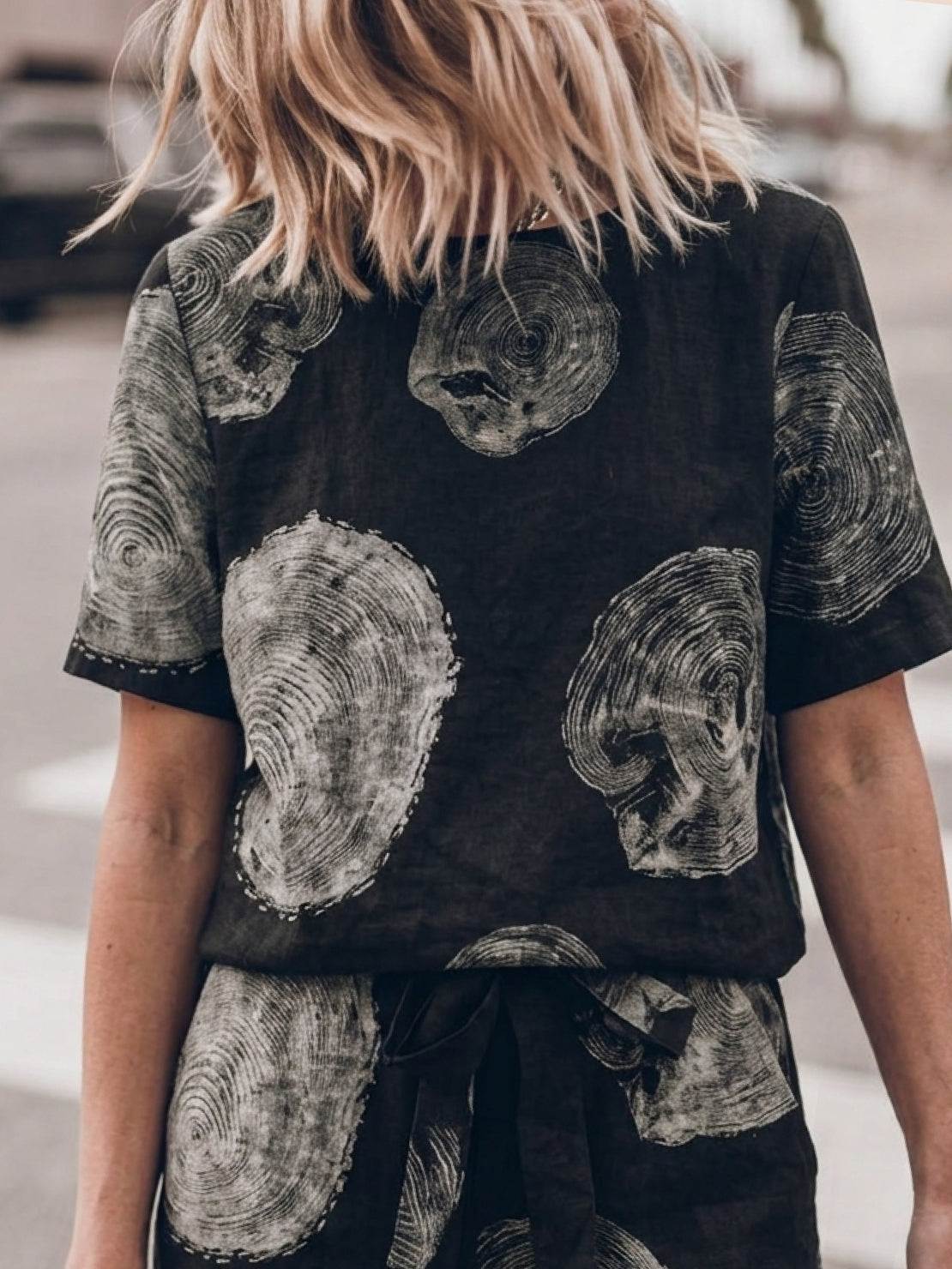 Woman wearing relaxed cotton linen set with short-sleeve top and straight-leg pants in monochrome tones