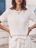 Woman wearing relaxed cotton linen set with short-sleeve top and straight-leg pants in monochrome tones