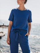 Woman wearing a relaxed cotton linen set with short-sleeve top and straight-leg pants in monochrome tones